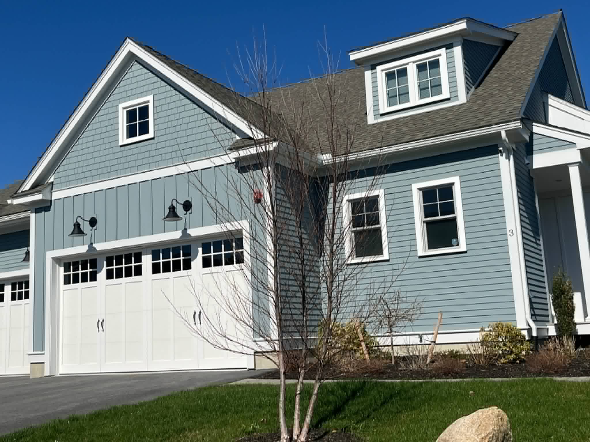 Newly sided home with light blue clapboard and shake siding