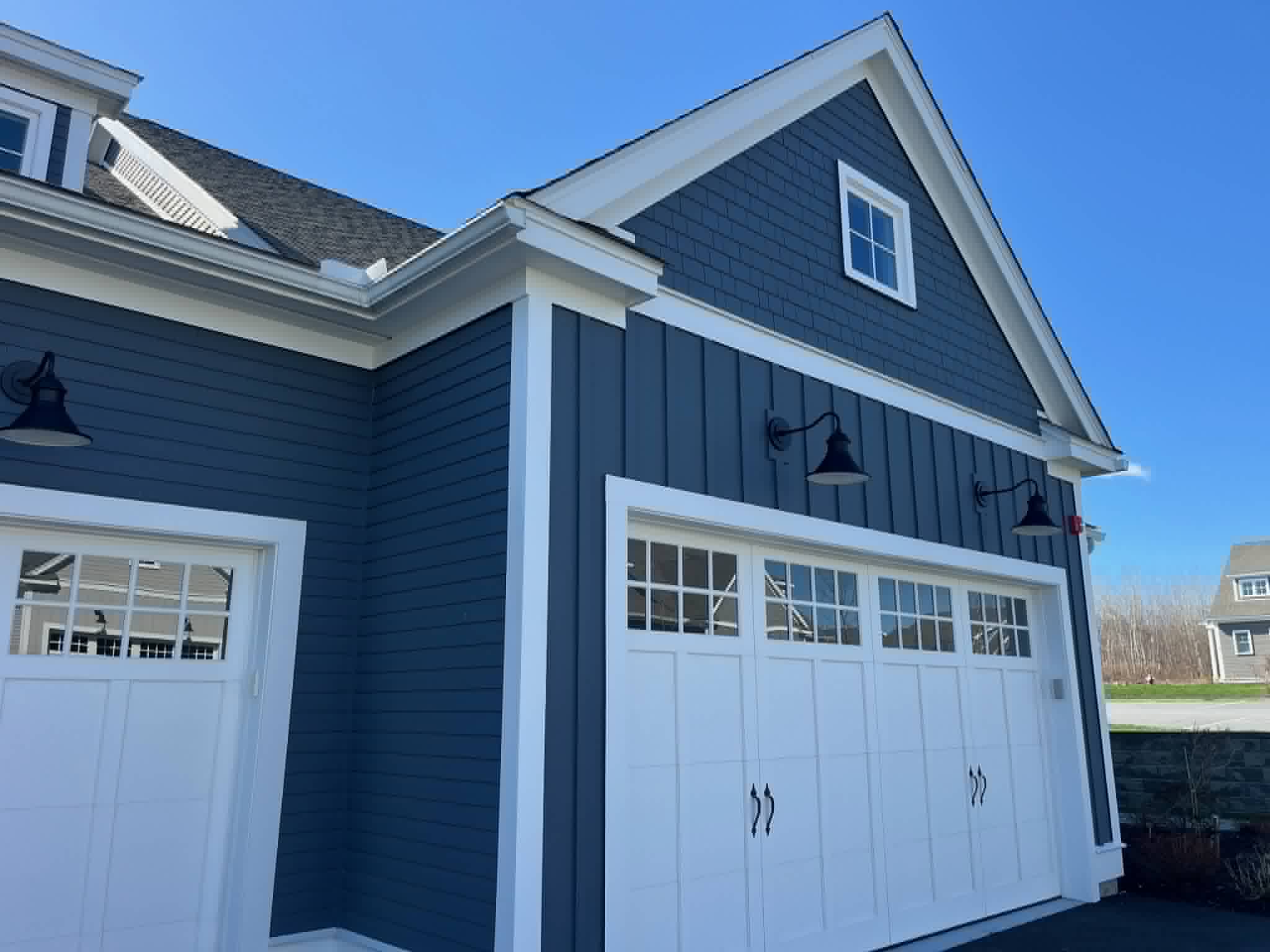 Close-up of new dark blue board-and-batten and shake siding on garage